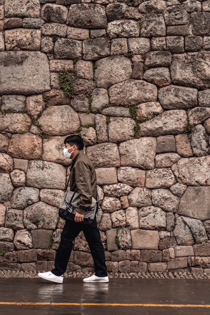 a person standing in front of a stone wall